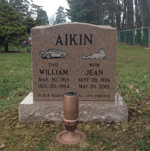 upright headstone with car and cat etchings