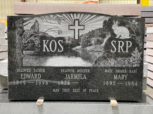 upright headstone with etched nature scene
