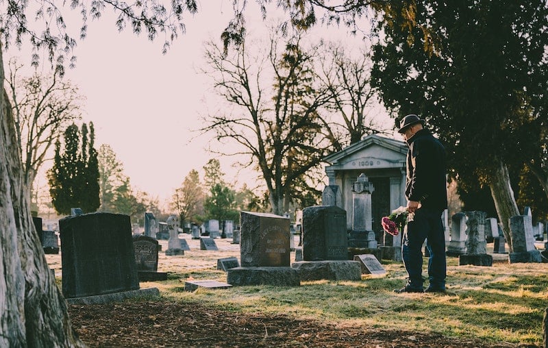 Traditional Monumental Cemetery with Man Holding Flowers